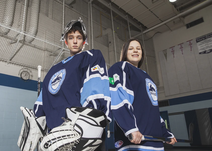 deux élèves, une fille et un garçon en habit de hockey
