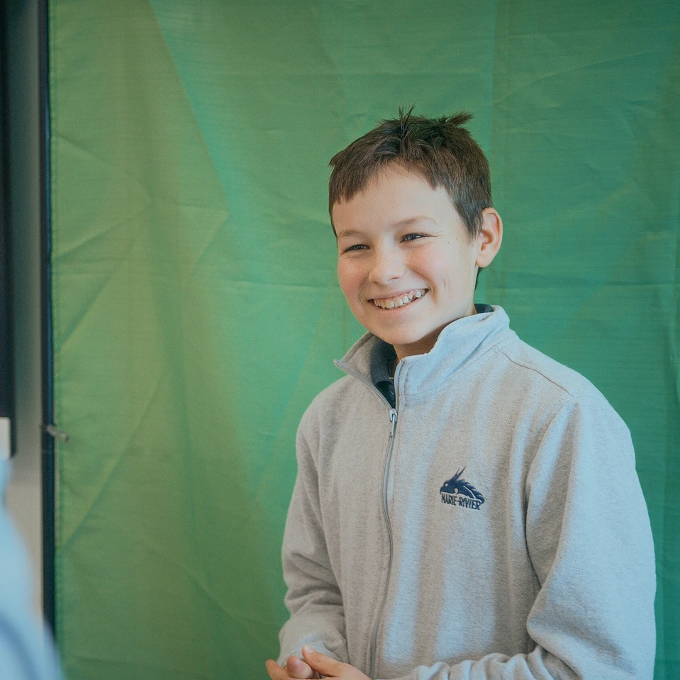 élève qui prend la pose pour une photo professionnel arborant un chandail de l'uniforme