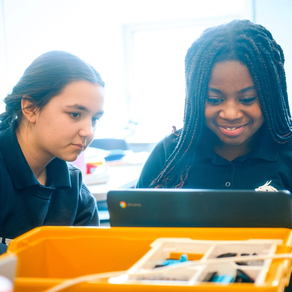 deux élèves assises devant un ordinateur à l'école