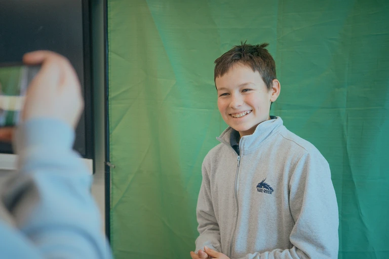 élève qui prend la pose pour une photo professionnel arborant un chandail de l'uniforme
