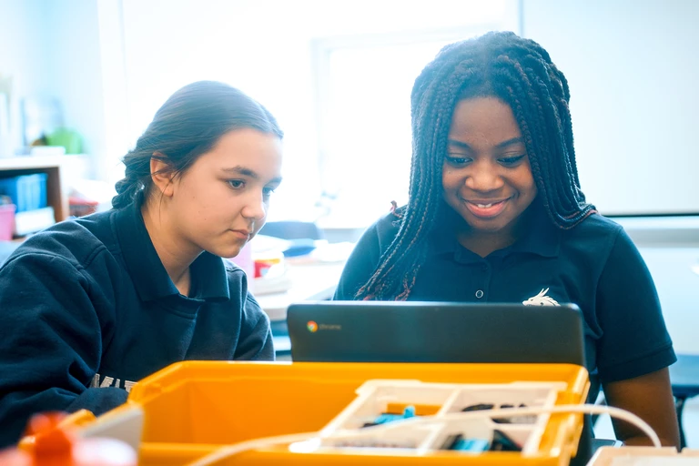 deux élèves assises devant un ordinateur à l'école