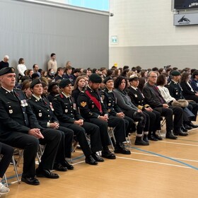 Cérémonie du Jour du Souvenir à l’école, élèves rassemblés pour remercier les Forces armées canadiennes et s’engager à être porteurs de paix.